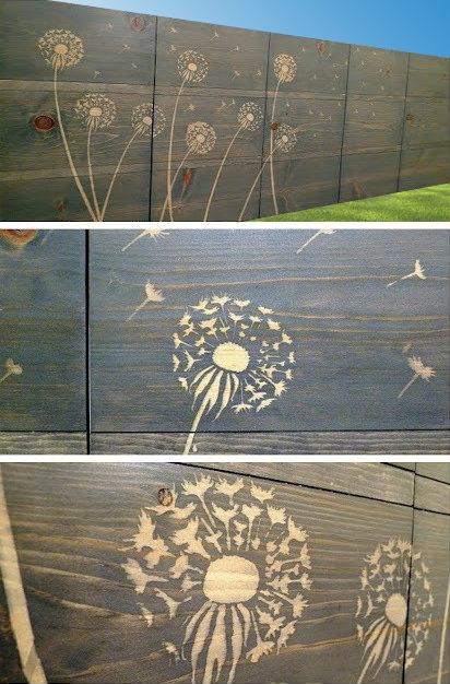 A solid wooden fence with patterns of dandelions